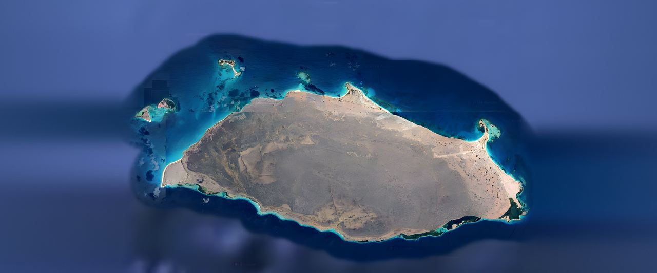 Top-down view of the whole of Isla La Tortuga and its cays, ringed by turquoise reefs